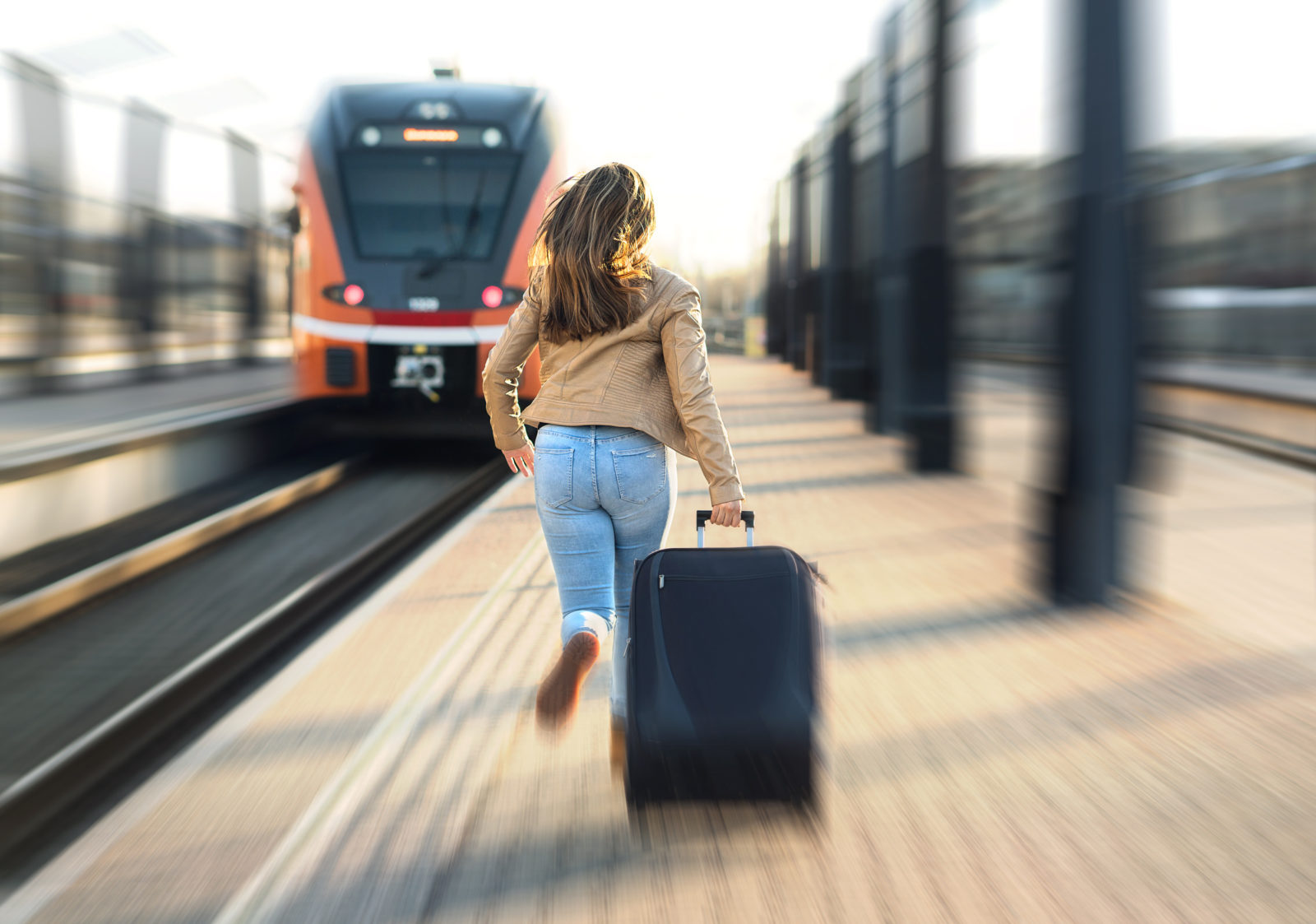 woman is late for train and rushes down the platform to catch it