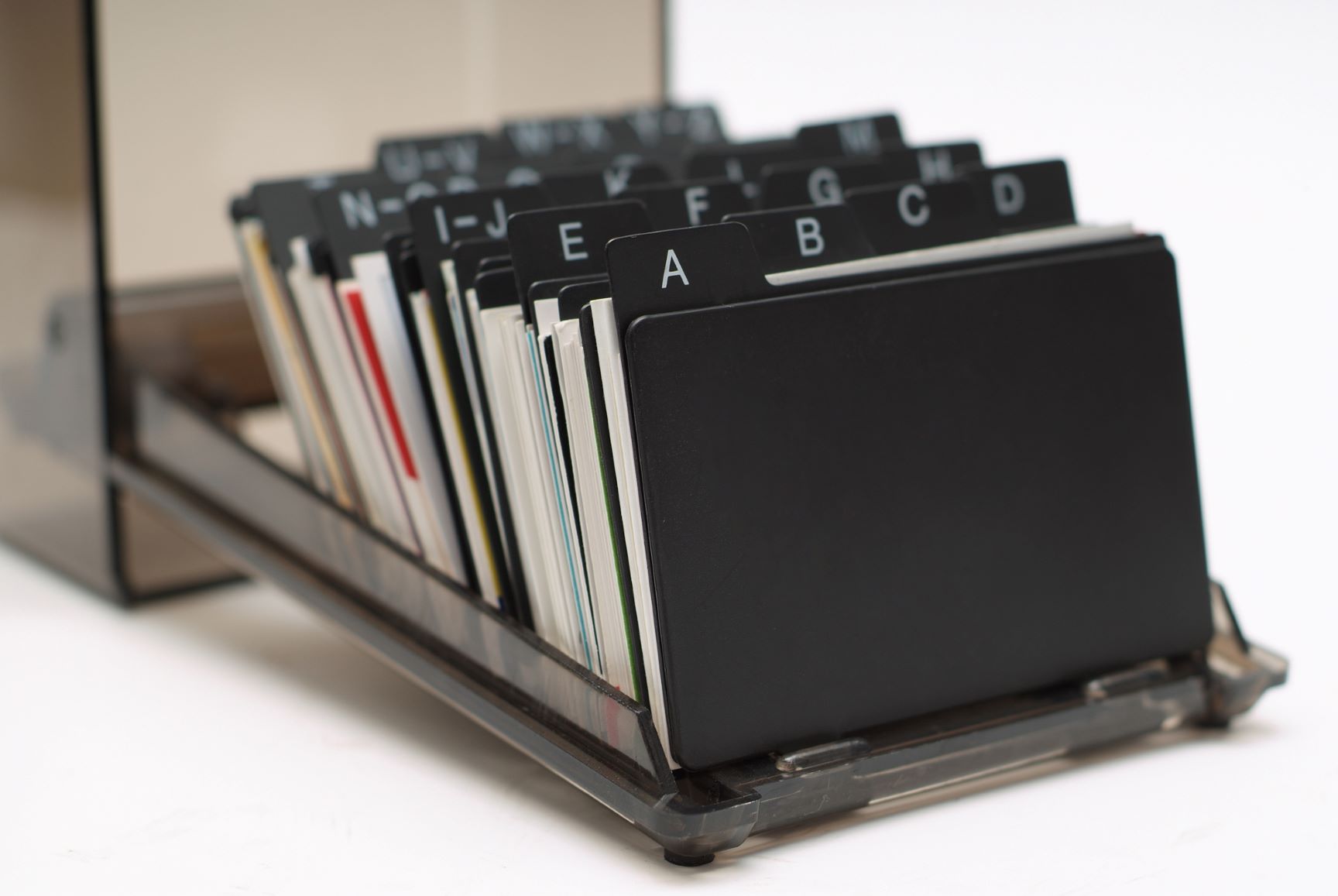 Close-up view of a Rolodex, alphabetically organizing index cards with the names and contact information of different sales leads.